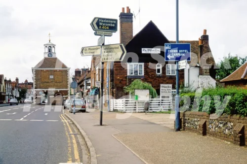 A 1980s photograph of the High Street in Amersham, Buckinghamshire, showing the intersection of the A404 and A416 with the historic Market Hall and The Willow Tree Tea Rooms in the background.