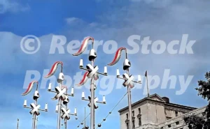A 1950s colour photo of ornate Coronation decorations in Whitehall, London, featuring tall standards topped with "guards' helmets" and red-and-white plumes designed by Sir Hugh Casson.
