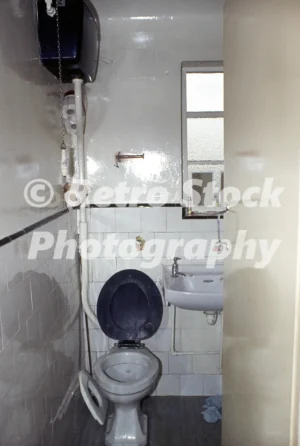 1970s high-flush toilet with wall-mounted cistern and pull chain