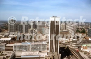 A 1970s aerial view of the Nestlé Tower and the Croydon skyline featuring Brutalist high-rise buildings and a red double-decker bus on the road below.
