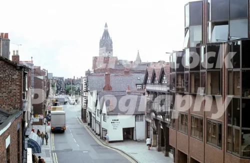 1980s photo of Northgate Street in Chester taken from the top of the Northgate, with the Odeon sign, Snow White children’s wear shop and Chester Town Hall tower in the distance.