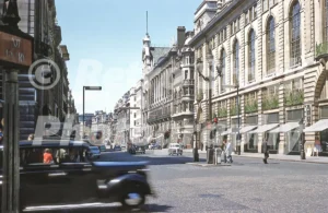 A 1950s colour photo of Piccadilly in London, looking west towards Green Park from the junction at Piccadilly Circus with the Swan & Edgar department store on the right.