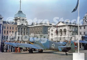 A 1950s colour photo of a captured German Messerschmitt Bf 109 aircraft on display at Horse Guards Parade in London.