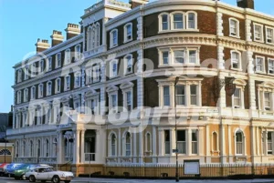 A 1970s photograph of the Queen Hotel in Chester, featuring its grand Victorian facade with white columns and brickwork, decorated with Silver Jubilee bunting