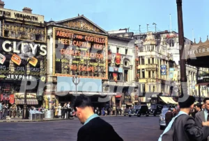 A 1950s colour photo of the London Pavilion in Piccadilly Circus, featuring a large film billboard for "Abbott and Costello Meet Captain Kidd" and festive decorations for the 1953 Coronation.