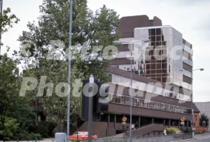 A 1974 photograph of Spire House on New Union Street in Coventry, West Midlands, showing the tiered brown brick office building with a distinctive gold-mirrored glass section
