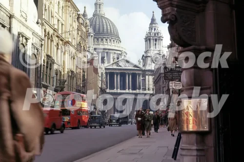 A 1960s colour photo of a red double-decker bus and pedestrians on Ludgate Hill looking toward the dome of St Paul's Cathedral in London in 1960.