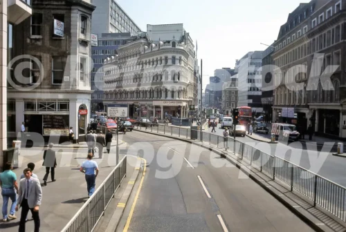 1980s photo of Cannon Street, London, with City Card Corner, red double-decker buses, central railings, office workers and a mix of Victorian and modern buildings.