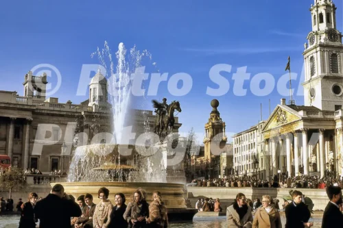 1970s photo of Trafalgar Square with a fountain, the National Gallery, St Martin-in-the-Fields and crowds in winter coats