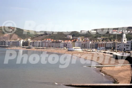 1970s view of Aberystwyth promenade and seafront in Wales with beach, terraces and Constitution Hill in the background