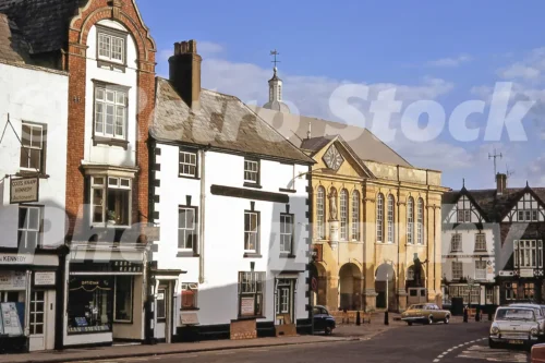 A 1972 photograph of Agincourt Square in Monmouth, featuring the Shire Hall with its statue of Henry V, alongside half-timbered buildings and period cars