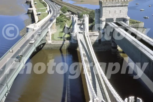 A 1970 high-angle view of the three bridges spanning the River Conwy, including the Telford Suspension Bridge and the tubular railway bridge near Conwy Castle.