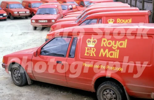 Royal Mail vans in the 1980s lined up in a depot yard, including Ford Escort and Morris Ital vans in red postal livery