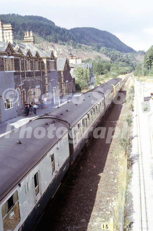 1970s view of Betws-y-Coed railway station in Wales with a British Rail diesel multiple unit and miniature railway tracks beside the former goods yard