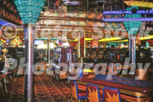 A 1990s colour photo of the 4 Queens Casino interior with turquoise neon pillars and rows of slot machines in 1998.