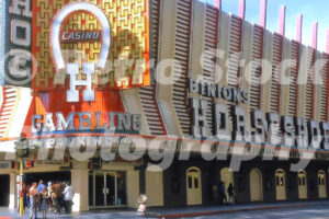 A 1970s colour photo of the exterior of Binion's Horseshoe Casino with large neon signage and a crowd gathered by the entrance in 1970.