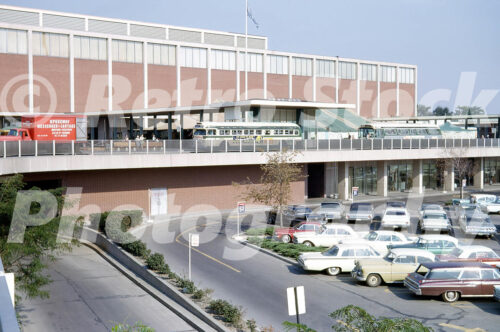 Bus terminal outside Hudson's, Northland Center, Southfield, Det A 1960s color photo of the bus terminal and parking lot at Northland Center in Southfield, Michigan, featuring vintage Detroit city buses, a Speedway Messenger truck, and the Hudson’s building.