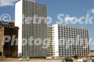 A 1950s color photo of the newly completed white marble City-County Building with vintage cars in the foreground in Detroit in 1955.