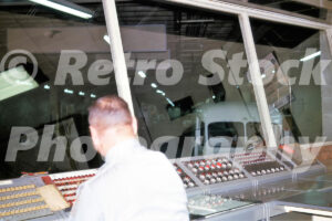 A 1960s color photo of a security guard monitoring a complex control console with numerous lights and switches, overlooking the underground delivery tunnel at Southdale Center in Edina, Minnesota.