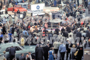 A 1960s color photo of a large crowd gathered around the Chrysler "Spin to Win" contest booth at the Detroit Auto Show in 1962.
