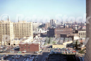 A 1970s color photo of the Detroit Leland Hotel and the Detroit Edison headquarters overlooking expansive downtown parking lots in 1970.
