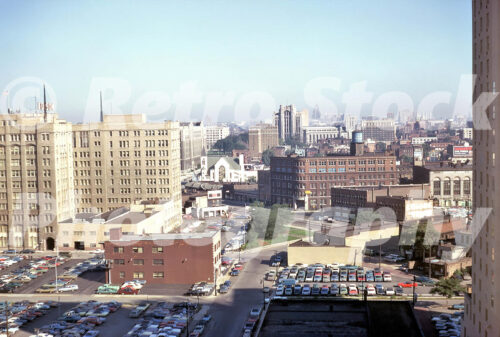 A 1970s color photo of the Detroit Leland Hotel and the Detroit Edison headquarters overlooking expansive downtown parking lots in 1970.