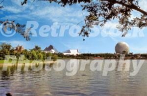 A 1980s color photo of Epcot Center at Walt Disney World in Florida, showing the World Showcase Lagoon with the Canada pavilion, Journey Into Imagination pyramids, and Spaceship Earth on the horizon