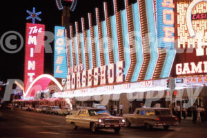 A 1960s color photo of the brilliant neon signs of Binion's Horseshoe and The Mint at night in Las Vegas in 1964.