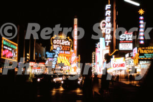 A 1960s colour photo of the glowing neon signs for the Golden Nugget, Lucky Casino, and Fremont Hotel at night in Las Vegas in 1960s.