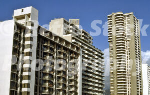 A 1980s color photo of high-rise hotels and condominium buildings in Waikiki, Honolulu, featuring white balconies and modern architectural designs against a blue sky.