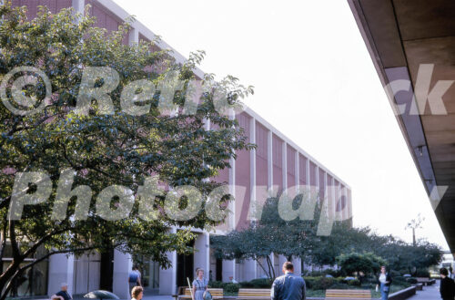 A 1960s color photo of the J.L. Hudson Co. department store at Northland Center in Southfield, Michigan, featuring a long red brick facade with vertical white concrete pillars and landscaped garden courts.