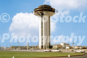 A 1960s colour photo of the Landmark Hotel construction site with the tower rising above a car park and green space in 1960s.