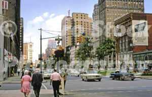 A 1960s color photo of pedestrians and classic cars at the intersection of State Street and Washington Boulevard in Detroit, Michigan in 1966.