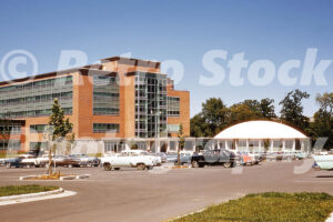 A 1950s color photo of the College of Education building and the dome-shaped Kiva at Michigan State University in East Lansing, with a parking lot of vintage 1950s cars.