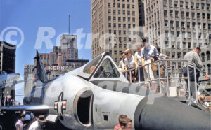 A 1950s colour photo of visitors on a viewing platform looking at a U.S. Air Force fighter jet in downtown Detroit, Michigan in 1950s.