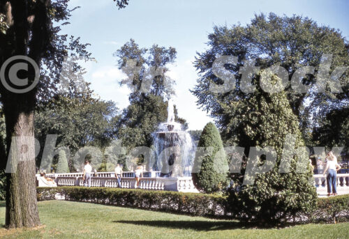 A 1950s British colour photo of visitors walking past the tiered Rackham Fountain surrounded by lush greenery at the Detroit Zoo in Royal Oak, Detroit, Michigan in 1957.