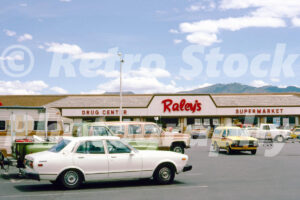 A 1980s colour photo of the Raley's Supermarket storefront with a white Datsun 810 and various utility vehicles in the car park in 1980s.