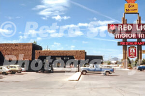 A 1980s color photo of the Red Lion Motor Inn and Restaurant sign in Elko Nevada with a blue Ford F-Series pickup truck in the parking lot in 1980s.