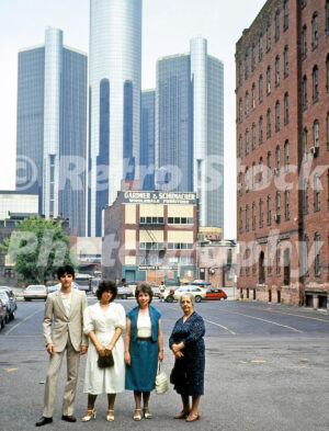 A 1980s colour photo of four people standing in a parking lot on Fort Street with the Renaissance Center towers in the background in Detroit, Michigan in 1982.