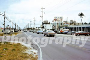 A 1970s color photo of Gulf Boulevard in Marathon, Florida, featuring the Salty Dog Motor Lodge, a "Roast Prime Ribs" restaurant sign, and a line of classic cars including a 1972 Cadillac Eldorado.