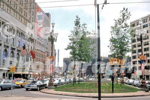 A 1960s color photo of Washington Boulevard with American flags and "Welcome Legionnaire" banners in front of the Sheraton-Cadillac Hotel in Detroit, Michigan in 1963.