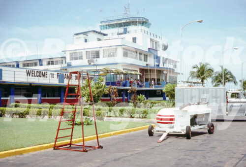 x A 1970s color photo of the Tocumen International Airport terminal and control tower in Panama in 1975 with a Braniff service truck.