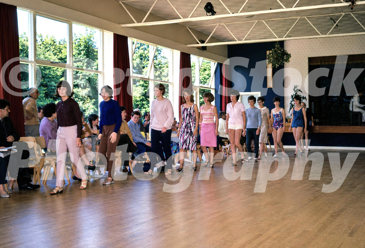 Pontins Dolphin Holiday Camp ballroom at Brixham in the 1960s with a fashion parade or contest, seated spectators and large picture windows
