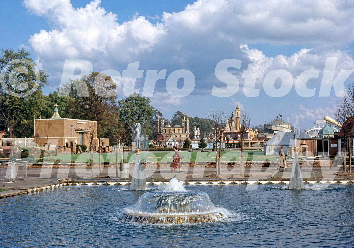 Vintage 1950s colour photo looking across ornamental pools towards the funfair at the Festival Pleasure Gardens in Battersea Park, London.
