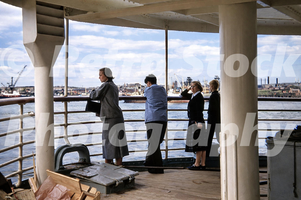 1950s photo aboard a Bergen Line ferry at Newcastle upon Tyne, with passengers at the rail looking across the River Tyne towards cranes and dockside industry.