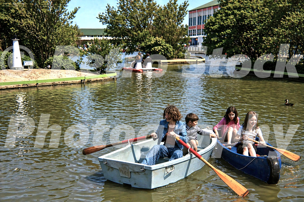 1970s photo of families boating on the boating lake at Butlins Bognor Regis holiday camp among landscaped islands and small bridges