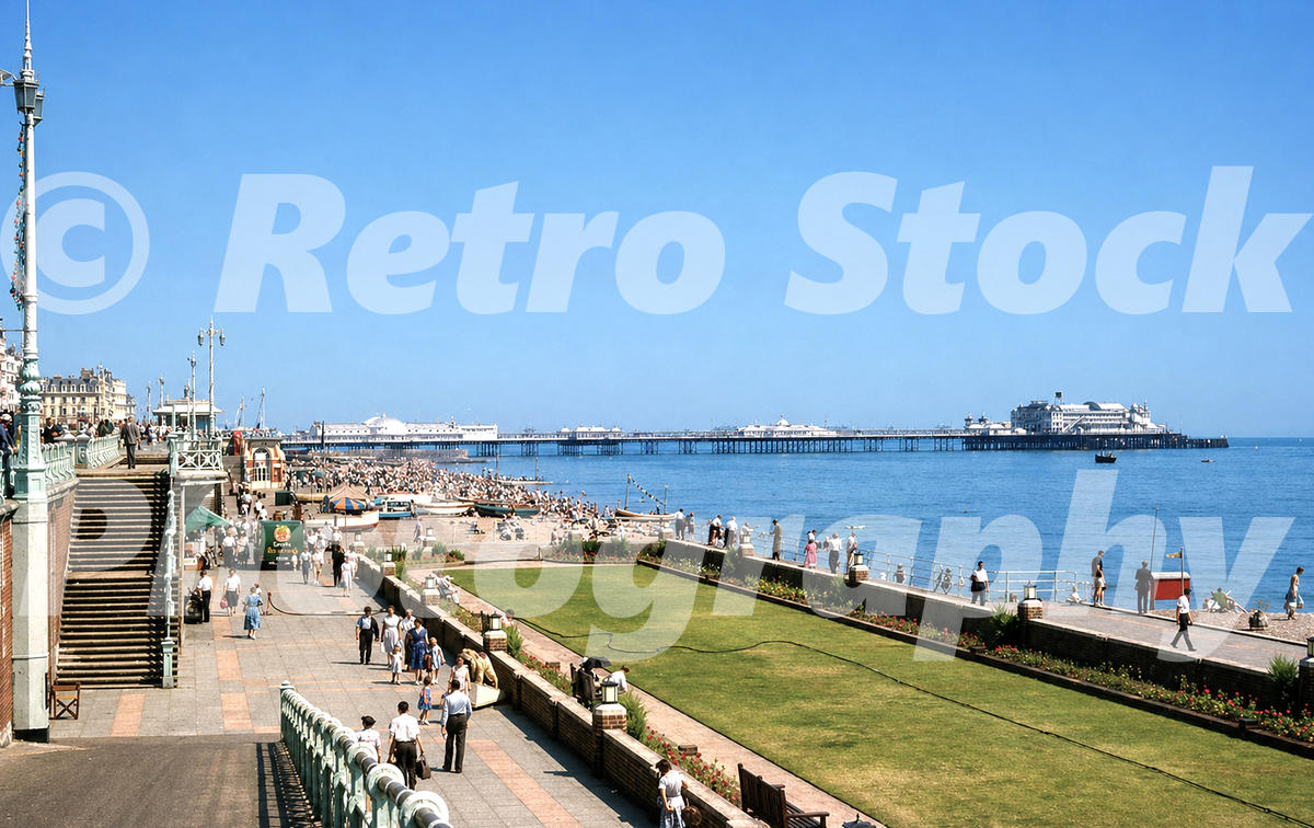 1950s photo of Brighton seafront and beach, with crowds on the shore, formal lawns and Brighton Palace Pier stretching into the sea.