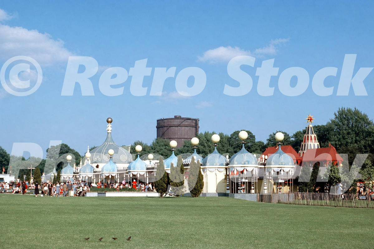 Vintage 1950s colour photo of the Festival Pleasure Gardens in Battersea Park, London, with domed pavilions and a gas holder in the background.