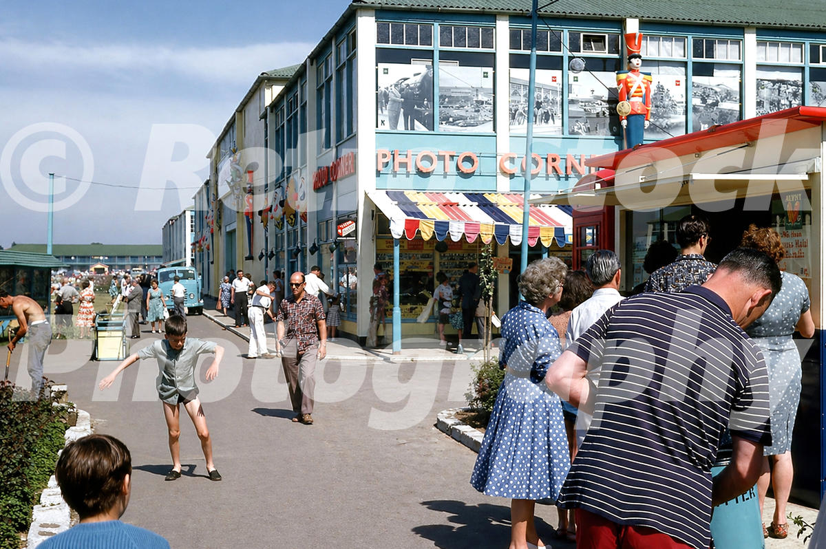 Butlins Bognor Regis Photo Corner in the 1960s with striped awning, toy soldier figure, enlarged photo displays and holidaymakers on the camp walkway