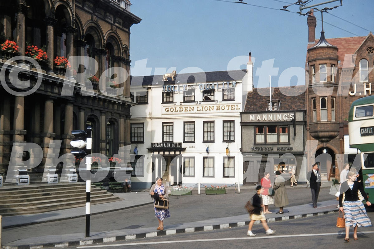 1950s view of Cornhill in Ipswich with the Golden Lion Hotel, Town Hall, pedestrians and a passing bus.